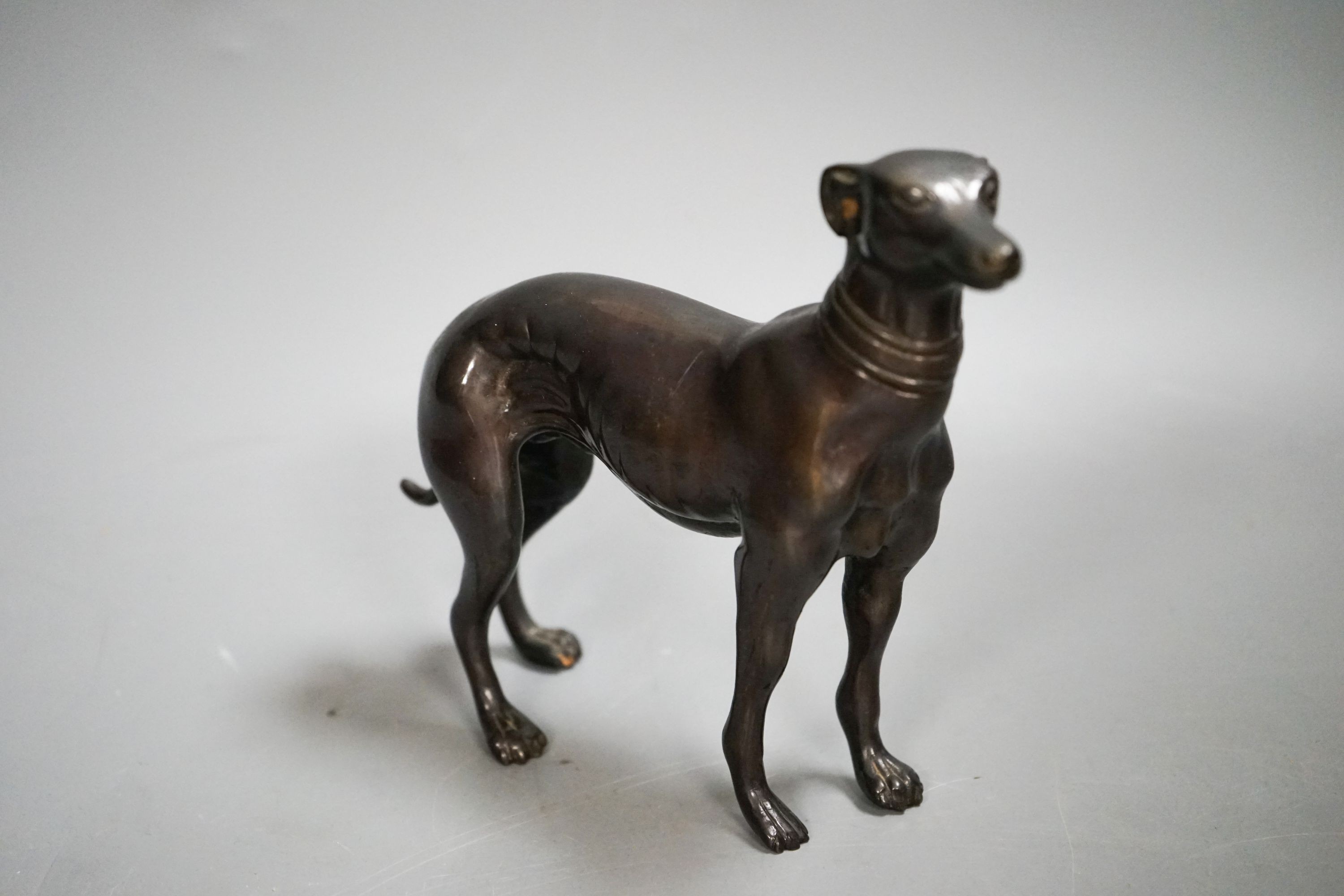 A bronzed metal greyhound, an Edwardian oak letter rack and a sarcophagus tea caddy.